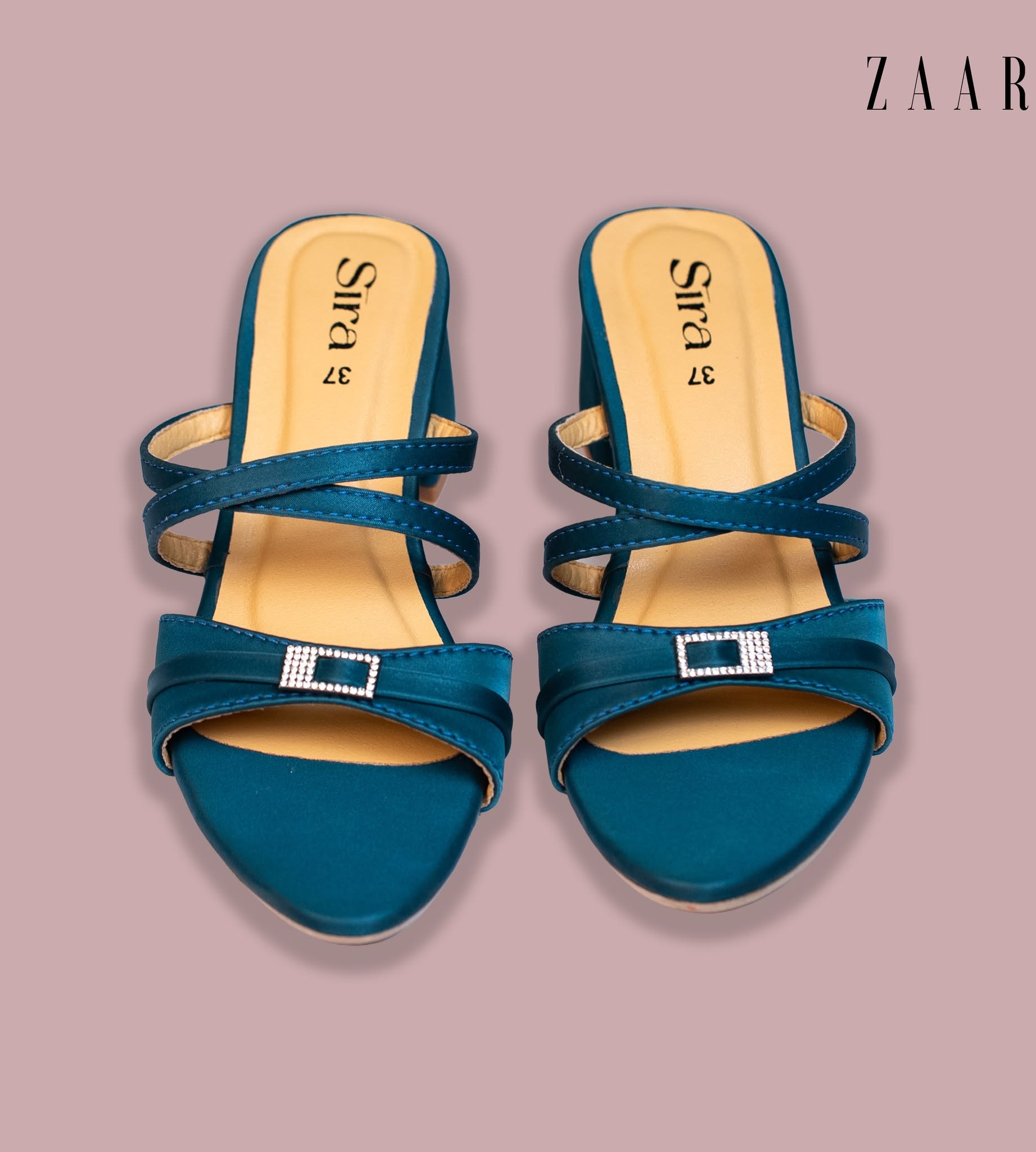 A pair of Sira teal satin mules with crystal buckles, seen from above.