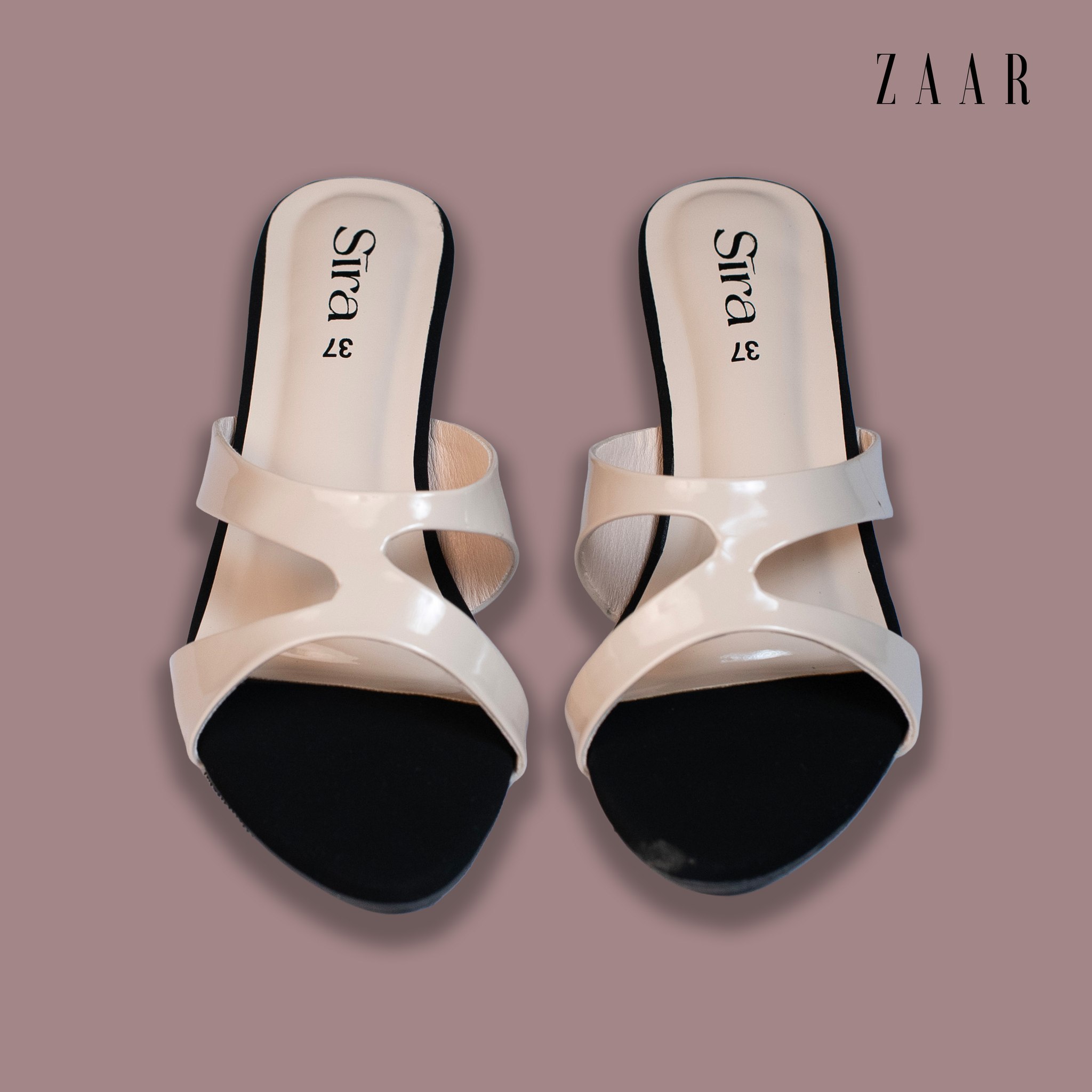 A pair of Sira cream patent cut-out mules, seen from above.