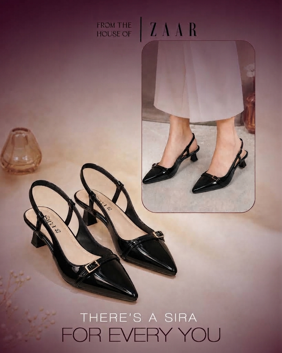 A pair of Sira black patent slingback kitten heels, with the pair worn behind.
